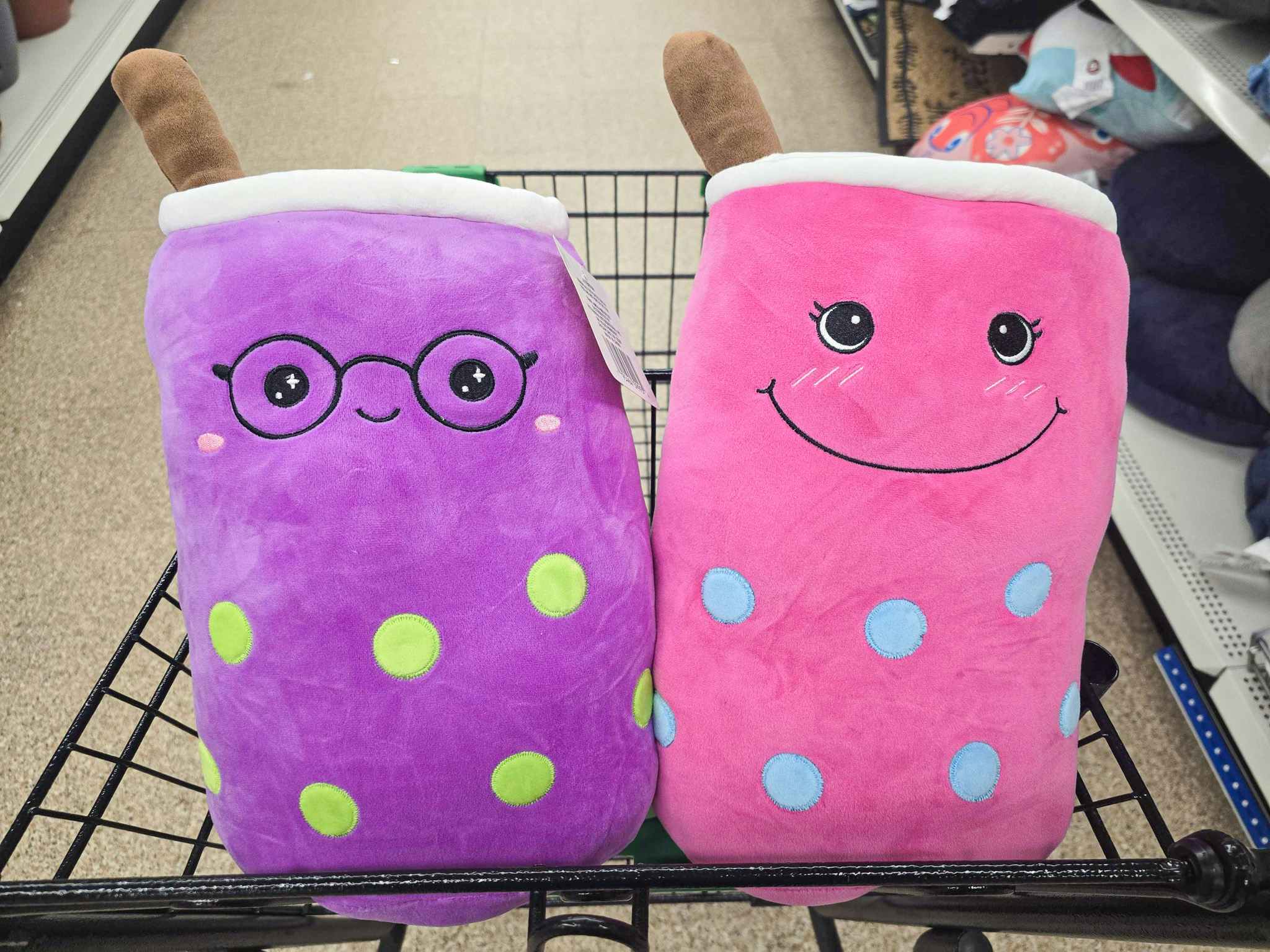 purple and pink large boba plushes in a cart