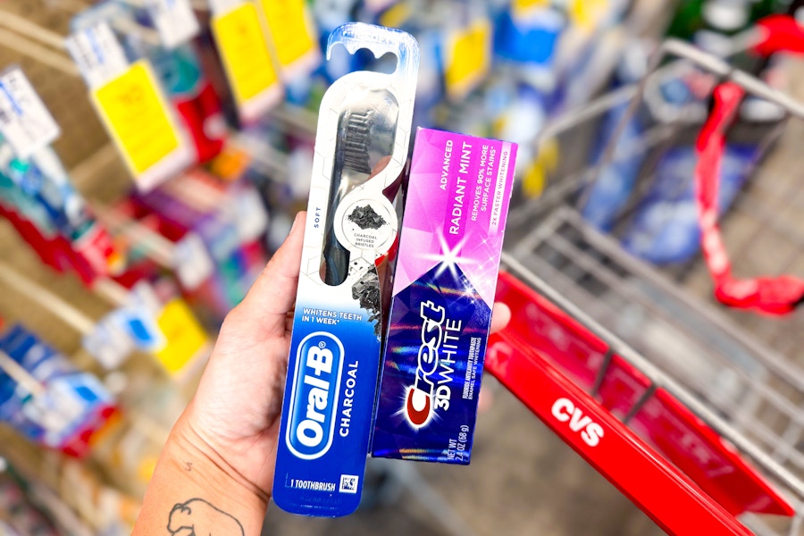 hand holding crest and oral-b products by a cvs shopping cart
