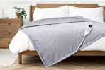 Lifestyle image of the gray Justlet heated throw blanket on bed