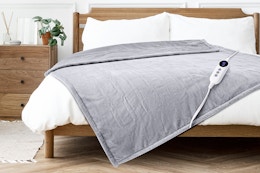 Lifestyle image of the gray Justlet heated throw blanket on bed