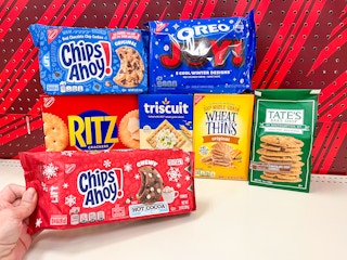 hand holding the red package of Chips Ahoy! holiday cookies with Chips Ahoy!, Oreo Joy, Ritz, Triscuit, and Wheat Thins in the background