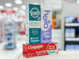 toms, hello, and colgate toothpastes on a shelf