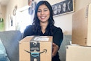 a person holding an amazon box while sitting on a couch 
