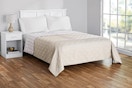 Lifestyle image of the king-sized Mainstays Farmhouse Quilt in beige (bedroom setting)