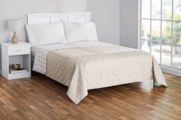 Lifestyle image of the king-sized Mainstays Farmhouse Quilt in beige (bedroom setting)