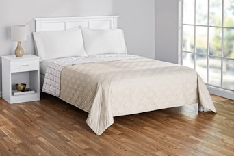 Lifestyle image of the king-sized Mainstays Farmhouse Quilt in beige (bedroom setting)