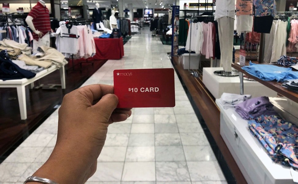 someone holding macys gift card at macys