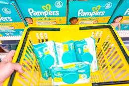 pampers wipes in a yellow shopping basket in front of pampers diapers