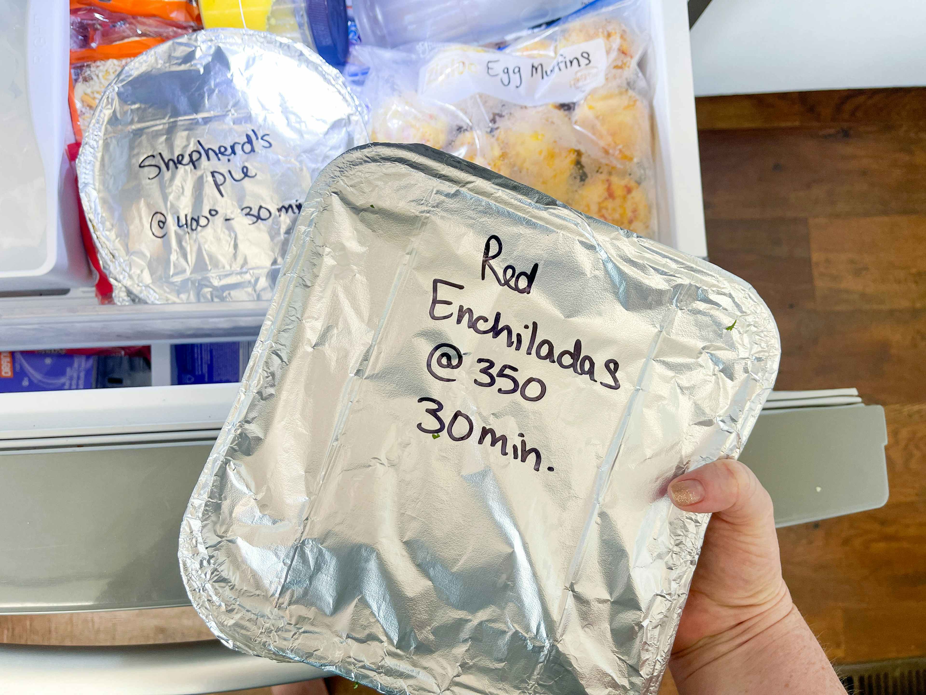 Red Enchilada in a freezer tin being put into a freezer 