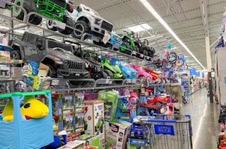 area photo of ride-on toy section at walmart with cart in aisle