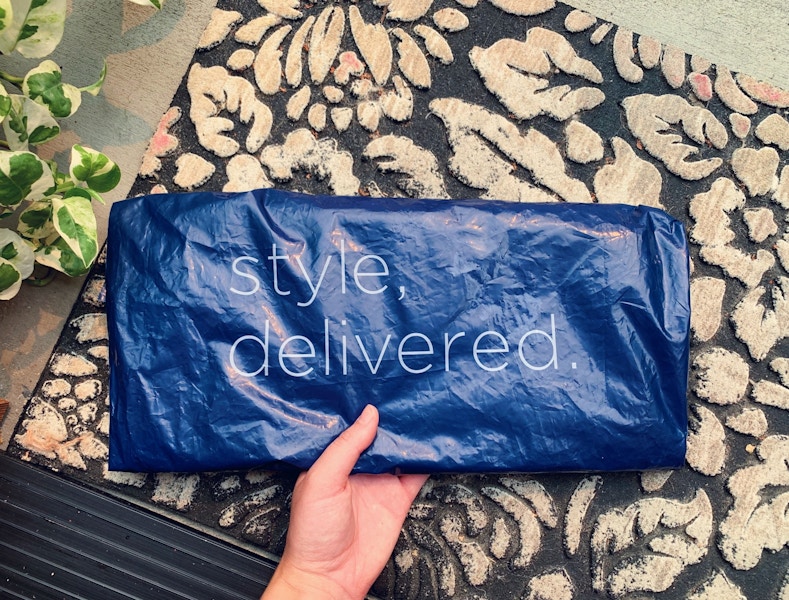 Someone picking up a package on their front porch from Old Navy