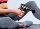 a person using a massage gun on their leg
