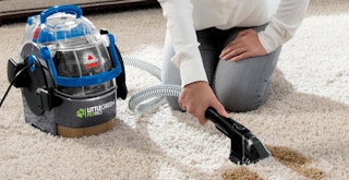 best carpet cleaner for pets - Someone using a BISSELL Little Green Pet Pro spot cleaner on a carpet stain