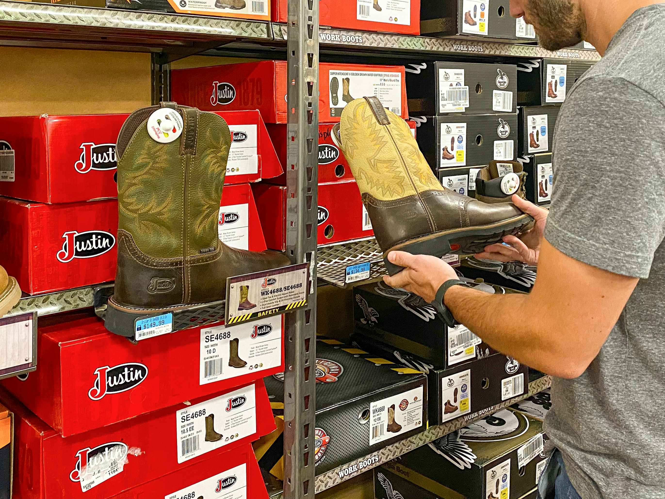 A man looking at Justin boots inside Tractor Supply.