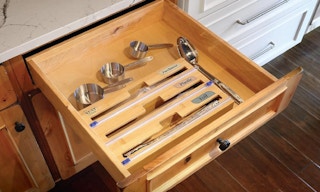 a bamboo foil and plastic wrap organizer in a kitchen drawer