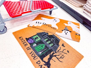 halloween doormats together in front of a parked target cart