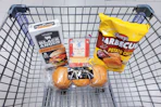burgers, buns, sliced cheese, and chips in a cart