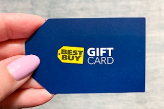 A person holding a Best Buy gift card.
