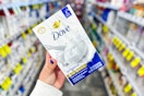 person holding a pack of dove bar soap in an aisle