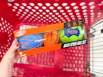 hand holding a nerf sports ball set over a target cart