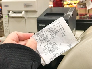Someone checking their receipt in a store