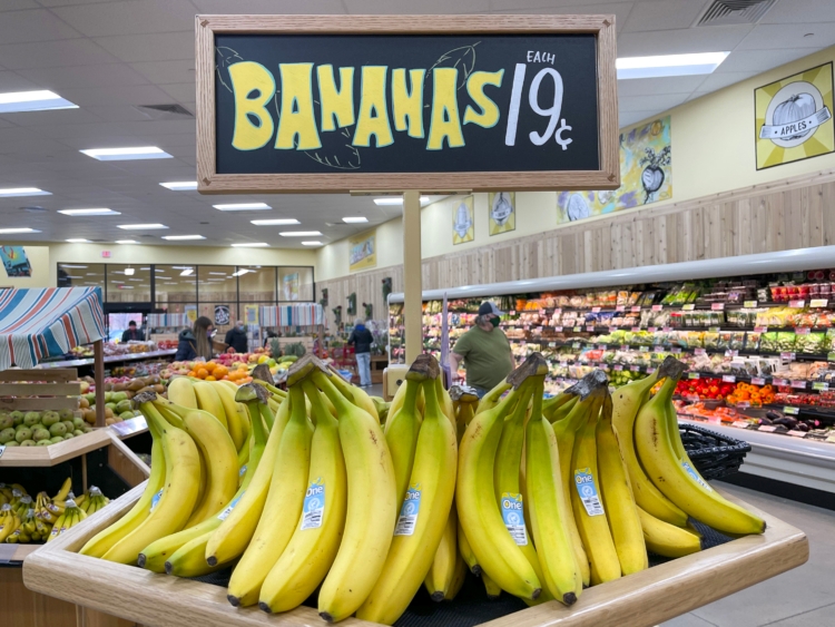 Bananas on a stand with a sign above them reading, "Bananas $0.19 each"