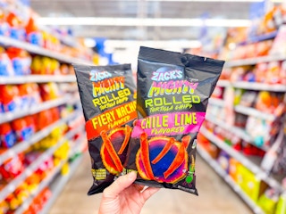 hand holding two bags of zacks mighty rolled chips in walmart aisle