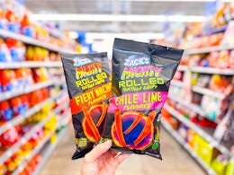 hand holding two bags of zacks mighty rolled chips in walmart aisle