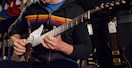 person playing a guitar inside of a guitar center