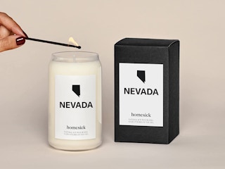 A hand lighting a Nevada Homesick candle.