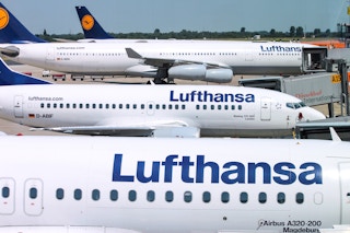 Multiple Lufthansa aircrafts waiting at an airport