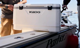 two people holding a cooler on a boat