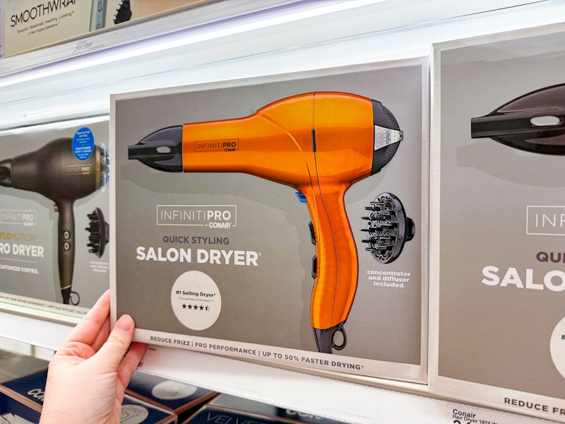 person grabbing a hair dryer box from the shelf