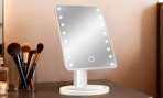 a lighted mirror on a desk