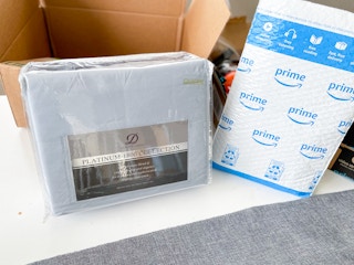 a sheet set in packaging next to an Amazon mailer and box