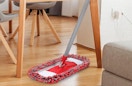 a red and grey dust mop on hardwood floors