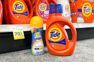 a bottle of tide detergent and a bottle of snuggle scent beads on the floor next to a clearance tag