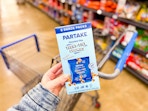 hand holding a box of partake teeny cookies over walmart cart