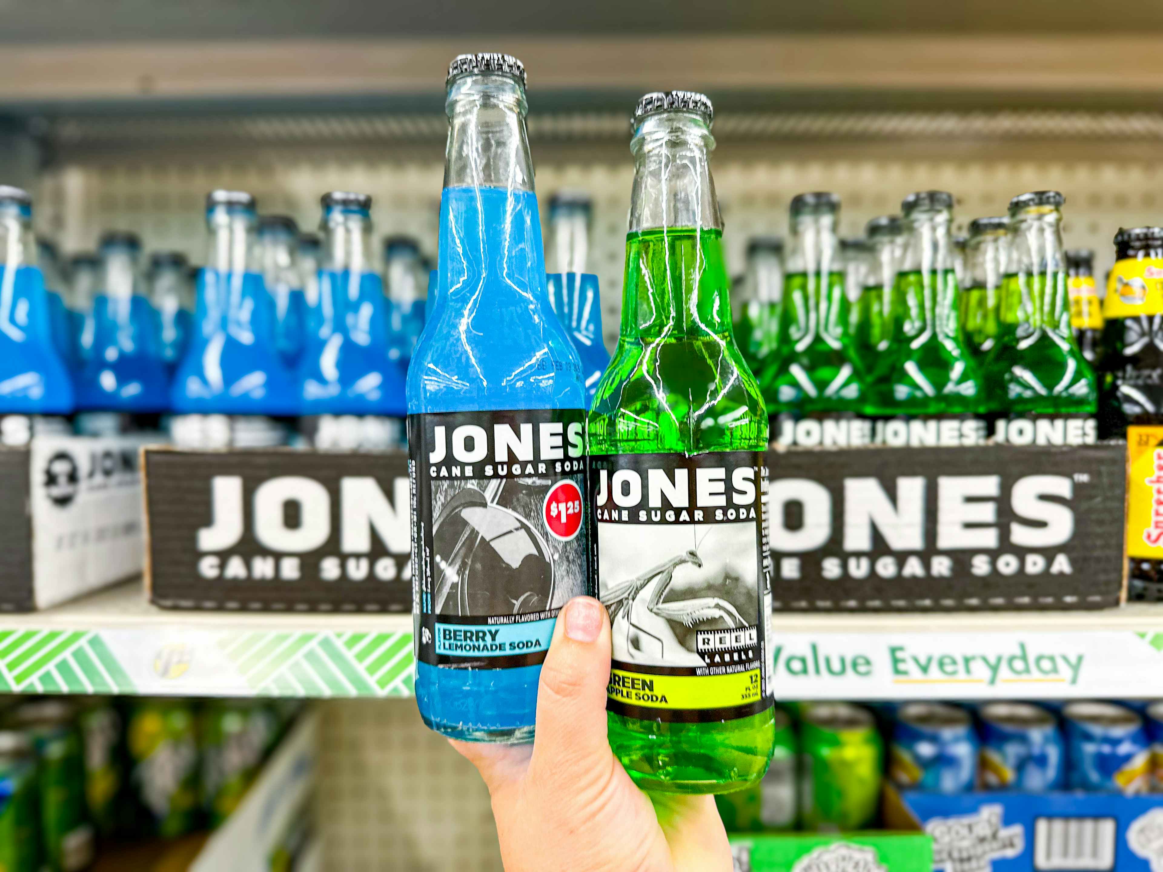 person holding 2 bottles of jones soda