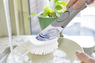 a dish brush scrubbing a dish