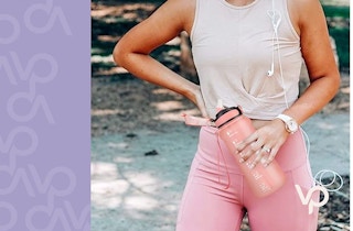 A woman holding a pink water bottle outside