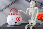 Lifestyle image of the Hyde and EEK! Boutique Bullseye Dog Halloween Trick or Treat Basket next to skeleton prop