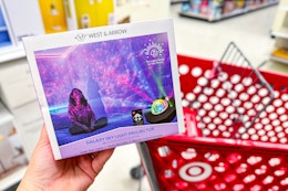 hand holding a west & arrow led galaxy light projector in front of a target cart