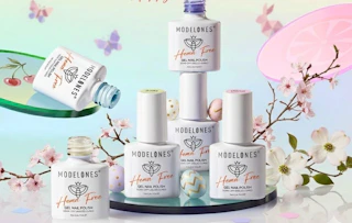 bottles of pastel gel nail polish on a display with flowers