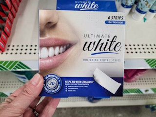 hand holding a box of teeth whitening strips