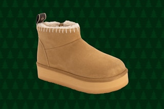 brown muk luks booties on green background