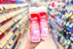 person holding 2 gillette venus shave gels in an aisle