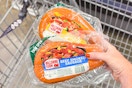 hand holding packs of hillshire farm smoked sausage