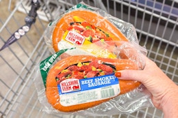 hand holding packs of hillshire farm smoked sausage