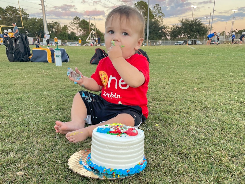 A baby eating a small smash cake